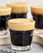 Espresso shot glasses with a creamy layer on top on a light background