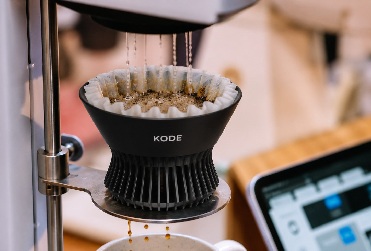 The KODE ribbed coffee brewer with a paper filter installed, brewing coffee on an automated pour-over system used for controlled coffee extraction at Coffee Spirit Co.