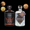 Two bottles of Norse Code and Cooper King liqueurs with awards on a black background