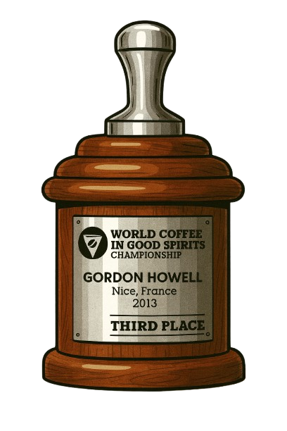 Wooden trophy with a silver top, engraved with 'World Coffee in Good Spirits Championship' details.